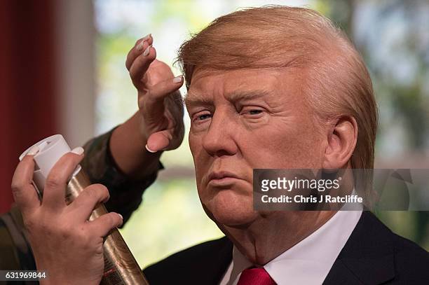 Hair stylist Gemma Sim applies finishing touches as Madame Tussauds unveils a wax figure of President-Elect Donald J. Trump ahead of the inauguration...
