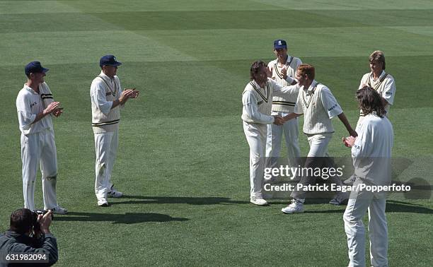 Shaun Pollock of Warwickshire is congratulated on his bowling figures of 6 for 21 by Warwickshire captain Dermot Reeve during the Benson and Hedges...