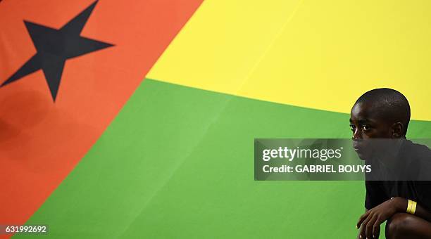 Player mascot squats next to Guinea-Bissau's flag ahead of the 2017 Africa Cup of Nations group A football match between Cameroon and Guinea-Bissau...