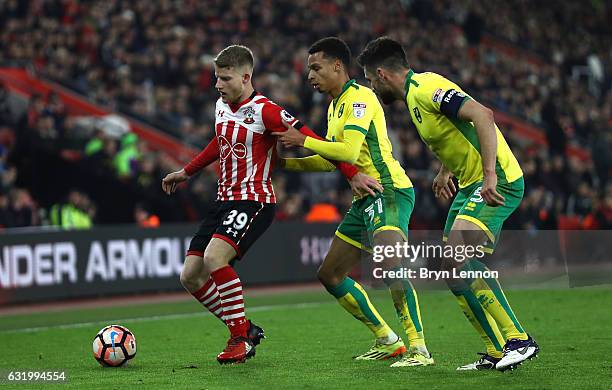 Josh Sims of Southampton is closed down by Josh Murphy and Russell Martin of Norwich City during The Emirates FA Cup Third Round Replay match between...