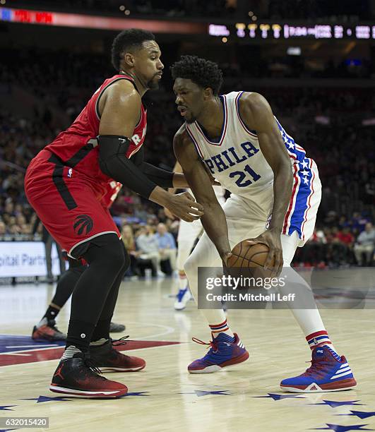 Joel Embiid of the Philadelphia 76ers controls the ball against Jared Sullinger of the Toronto Raptors at the Wells Fargo Center on January 18, 2017...