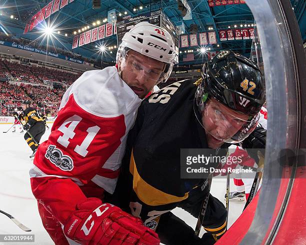 Luke Glendening of the Detroit Red Wings battles along the boards with David Backes of the Boston Bruins during an NHL game at Joe Louis Arena on...