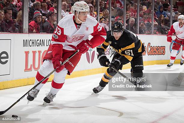 Alexey Marchenko of the Detroit Red Wings skates with the puck followed by Ryan Spooner of the Boston Bruins during an NHL game at Joe Louis Arena on...