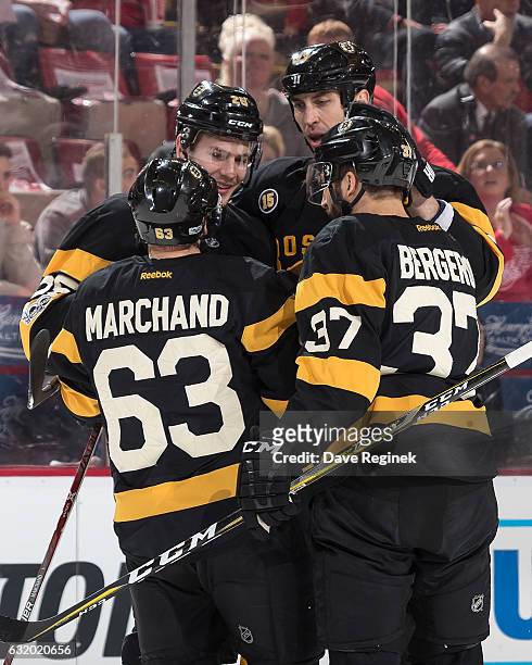 Brandon Carlo of the Boston Bruins celebrates his first period goal with teammates Brad Marchand, Patrice Bergeron and Zdeno Chara during an NHL game...