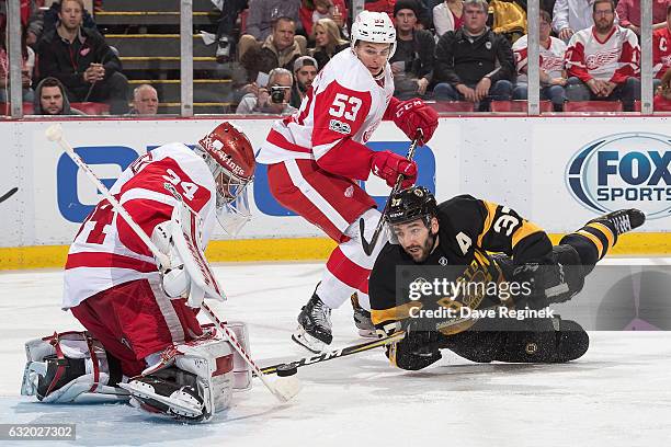 Petr Mrazek of the Detroit Red Wings makes a save as teammate Alexey Marchenko defends against Patrice Bergeron of the Boston Bruins during an NHL...