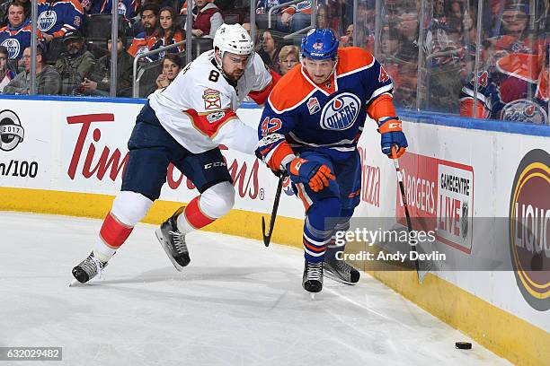 Anton Slepyshev of the Edmonton Oilers battles for the puck against Dylan McIlrath of the Florida Panthers on January 18, 2017 at Rogers Place in...