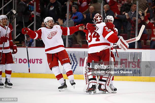 Petr Mrazek of the Detroit Red Wings celebrates a 6-5 shootout win over the Boston Bruins with Tomas Tatar and Xavier Ouellet Joe Louis Arena on...