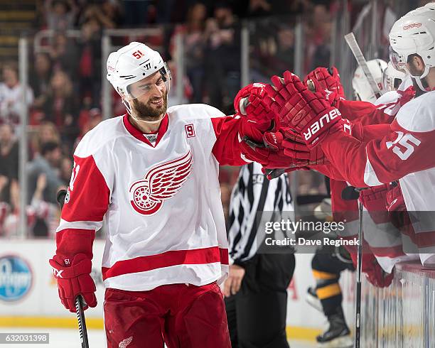 Frans Nielsen of the Detroit Red Wings pounds gloves with teammates on the bench following his game winning shoot-out goal during an NHL game against...