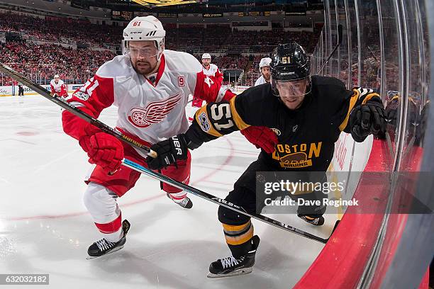 Xavier Ouellet of the Detroit Red Wings battles along the boards with Ryan Spooner of the Boston Bruins during an NHL game at Joe Louis Arena on...
