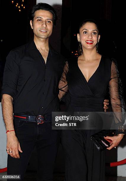 Indian Bollywood actor Apurva Agnihotri and his wife pose for a photograph during a promotional event in Mumbai on late January 18, 2017. / AFP / STR
