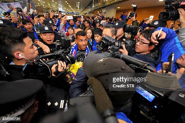 Argentine striker Carlos Tevez makes his way through the arrivals halls at Shanghai Pudong International Airport in Shanghai on January 19, 2017....