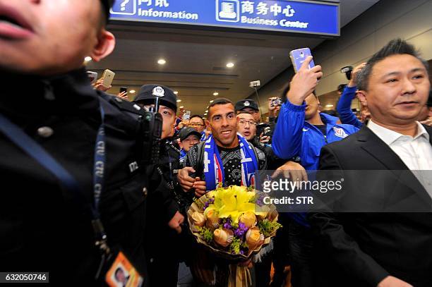 Argentine striker Carlos Tevez makes his way through the arrivals halls at Shanghai Pudong International Airport in Shanghai on January 19, 2017....