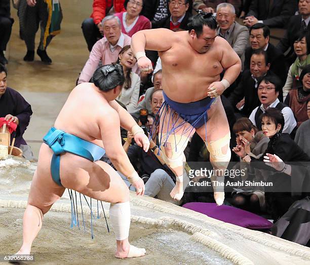 Mongolian sekiwake Tamawashi pushes ozeki Kotoshogiku out of the ring to win during day twelve of the Grand Sumo New Year Tournament at Ryogoku...