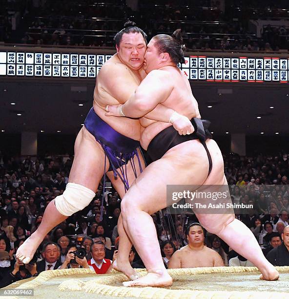 Mongolian wrestler Ichinojo pushes Hokutofuji out of the ring to win during day twelve of the Grand Sumo New Year Tournament at Ryogoku Kokugikan on...