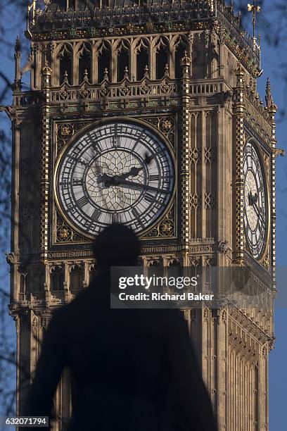 The silhouetted statue of Sir Robert Peel and the clockface containing the Big Ben bell in the Elizabeth Tower of the British parliament, on 17th...