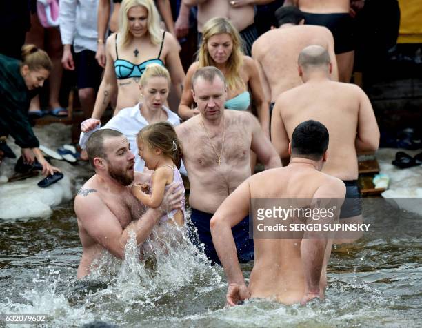 Orthodox Christian believers plunge into a cross-shaped hole cut into the Dniper River in Kiev on January 19 as part of Orthodox Epiphany...
