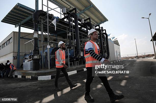 Palestinian employees work at a desalination plant during the inauguration of the first phase of the project on January 19 in Deir el-Balah in...