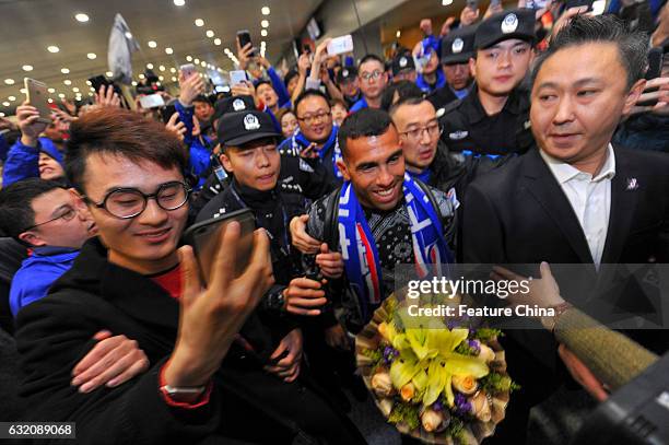 Argentine striker Carlos Tevez, makes his way through the crowd of fans upon arrival at Shanghai Pudong International Airport on January 19, 2017 in...