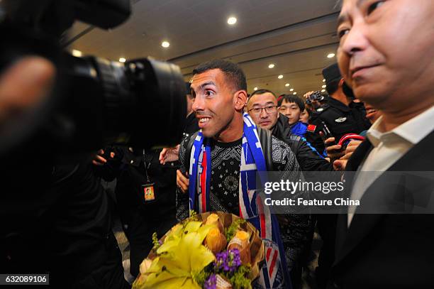 Argentine striker Carlos Tevez, makes his way through the crowd of fans upon arrival at Shanghai Pudong International Airport on January 19, 2017 in...