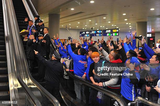 Argentine striker Carlos Tevez, makes his way through the crowd of fans upon arrival at Shanghai Pudong International Airport on January 19, 2017 in...