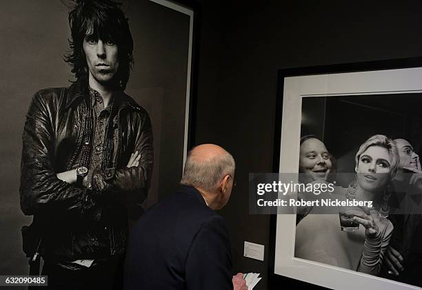 An unidentified viewer gazes at a 1965 photograph, right, called "Edie Sedgwick, Andy Warhol and Entourage" shot by photographer Steve Schapiro in...