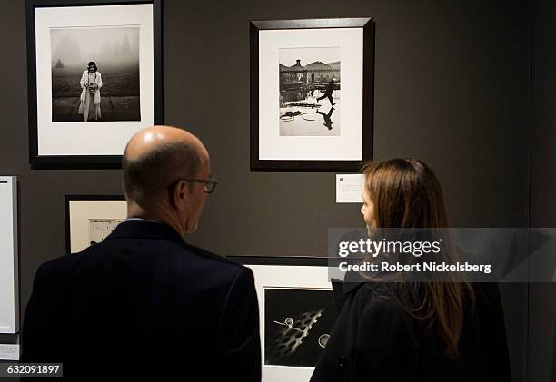 Two unidentified viewers gaze at a 1932 Henri Cartier-Bresson photograph called "Derriere la Gare Saint-Lazare," center, in New York, NY on April 17,...
