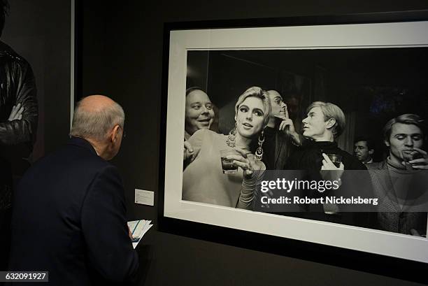 An unidentified viewer gazes at a 1965 photograph called "Edie Sedgwick, Andy Warhol and Entourage" shot by photographer Steve Schapiro in New York,...