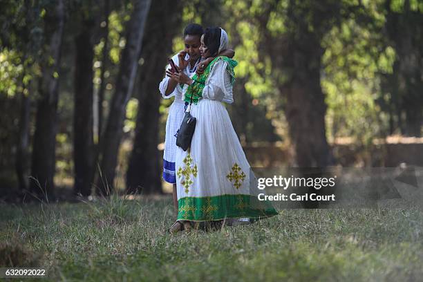 Women in traditional Ethiopian dress chat as they walk through a field during the annual Timkat Epiphany celebration on January 19, 2017 in Gondar,...