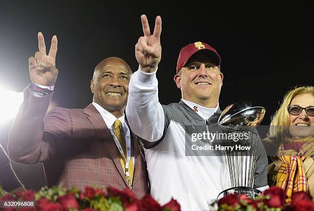 Trojans athletic director Lynn Swann and USC Trojans head coach Clay Helton pose with the 2017 Rose Bowl trophy after defeating the Penn State...