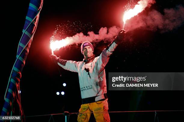 French skipper Armel Le Cleac'h celebrates aboard his Imoca monohull after crossing the finish line of the Vendee Globe solo around the world sailing...