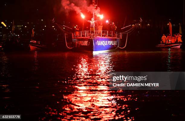 French skipper Armel Le Cleac'h celebrates aboard his Imoca monohull after crossing the finish line of the Vendee Globe solo around the world sailing...