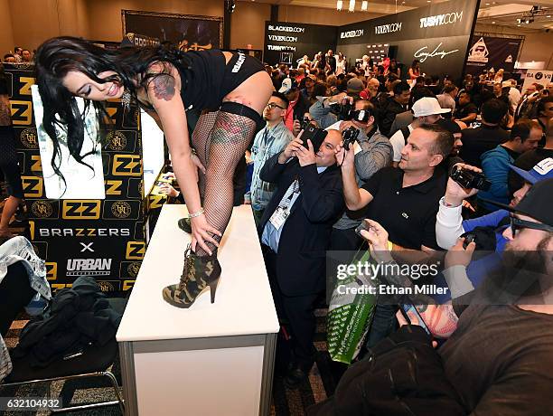 Attendees take photos of adult film actress Gina Valentina at the Reality Kings booth at the 2017 AVN Adult Entertainment Expo at the Hard Rock Hotel...