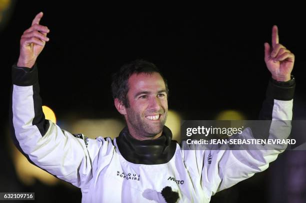 French skipper Armel Le Cleac'h celebrates aboard his Imoca monohull after crossing the finish line of the Vendee Globe solo around the world sailing...