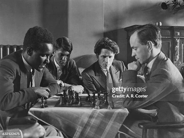 Ghanaian student playing a Russian at chess at Student Movement House in Russell Square, London, 26th May 1933. Looking on are a Sinhalese and a...