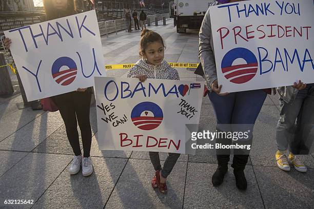 Pedestrians hold "Thank You" signs while walk along Pensilvania Avenue in Washington, D.C., on Thursday, Jan. 19, 2017. The president-elect will...
