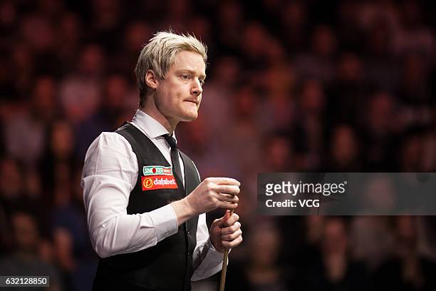 Neil Robertson of Australia chalks the cue during the quarterfinal match against Ronnie O'Sullivan of England on day five of the Dafabet Masters at...