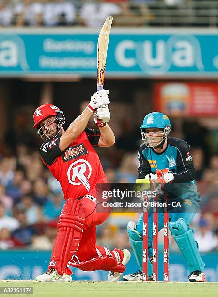 Aaron Finch of the Renegades hits a six as Heat keeper James Peirson looks on during the Big Bash League match between the Brisbane Heat and the...