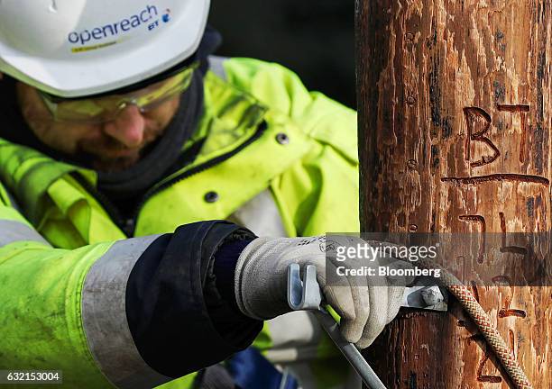 Trainee engineer from BT Openreach, a unit of BT Group Plc, attaches a safety harness whilst climbing a telegraph pole at the company's training...