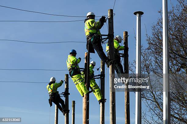 Trainee engineers from BT Openreach, a unit of BT Group Plc, carry out work at the top of telegraph poles at the company's training facility at West...
