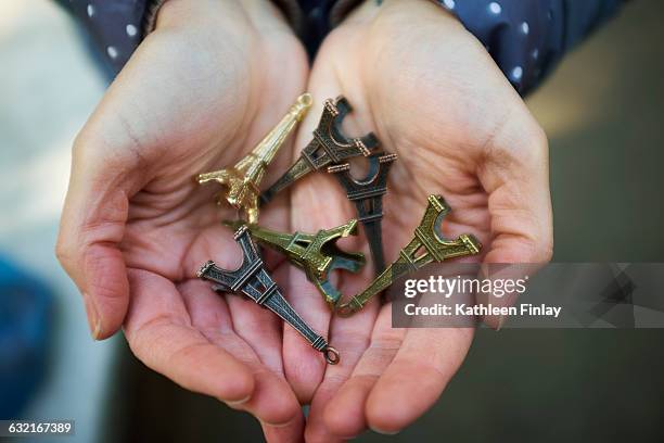 young woman holding eiffel tower souvenirs in hand, close-up - frankreich souvenir reise stock-fotos und bilder