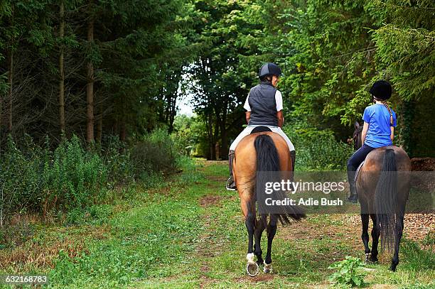 rear view of mature woman and girl horse riding - horseback riding stock pictures, royalty-free photos & images