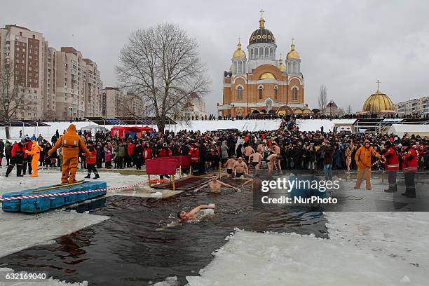 Ukrainian Orthodox believers bathe in cross-alike ice-holes on Dnipro river as they celebrate Epiphany in Kiev, Ukraine, on January 19, 2017.