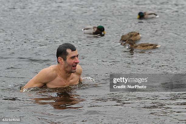 Ukrainian Orthodox believers bathe in cross-alike ice-holes on Dnipro river as they celebrate Epiphany in Kiev, Ukraine, on January 19, 2017.