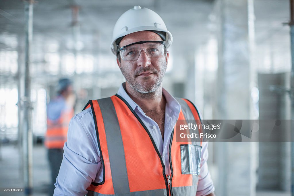 Portrait of mid adult male site manager on construction site