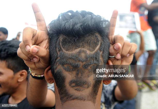 An Indian man with his hair shaved in the shape of a bull poses during a demonstration against the ban on the Jallikattu bull taming ritual in...