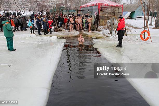 Ukrainian Orthodox believers bathe in cross-alike ice-holes on Dnipro river as they celebrate Epiphany.