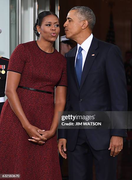 President Barack Obama and First Lady Michelle Obama kiss as they prepare to greet President-elect Donald Trump and his wife Melania to the White...