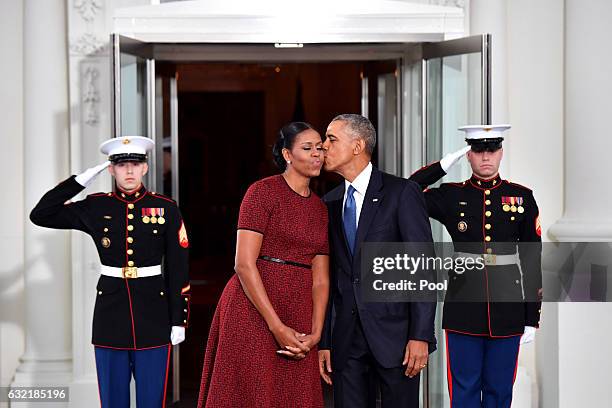 President Barack Obama gives Michelle Obama a kiss as they wait for President-elect Donald Trump and wife Melania at the White House before the...