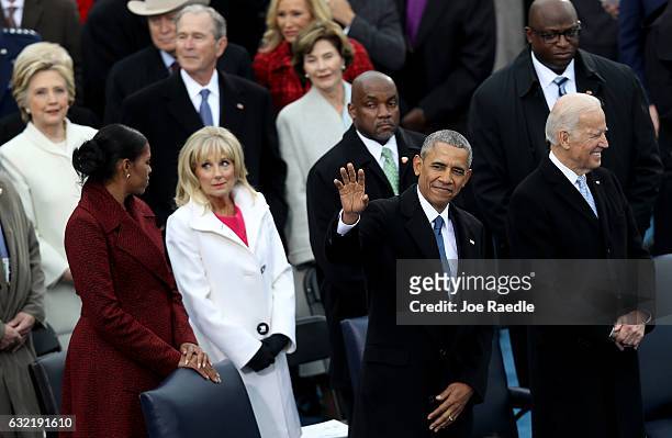 President Barack Obama waves to the crowd as Michelle Obama and Jill Biden stand by on the West Front of the U.S. Capitol on January 20, 2017 in...