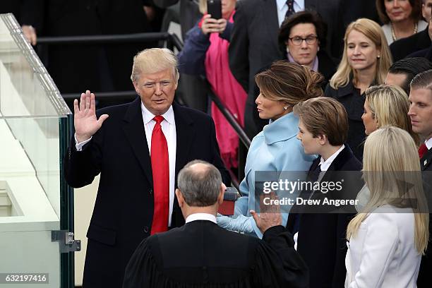 Supreme Court Justice John Roberts administers the oath of office to U.S. President Donald Trump as his wife Melania Trump holds the Bible on the...